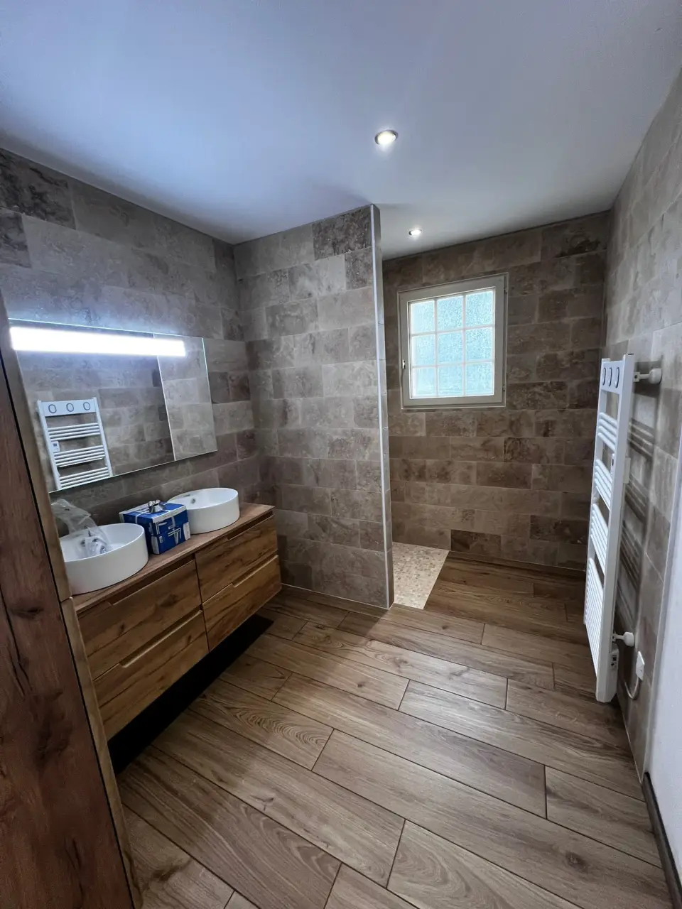 Salle de bains avec revêtements à l’aspect pierre et bois