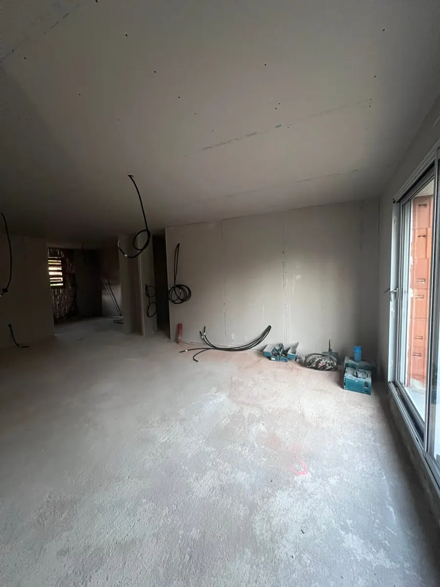 Pièce en travaux avec plafond en plaques de plâtre et passages de câbles