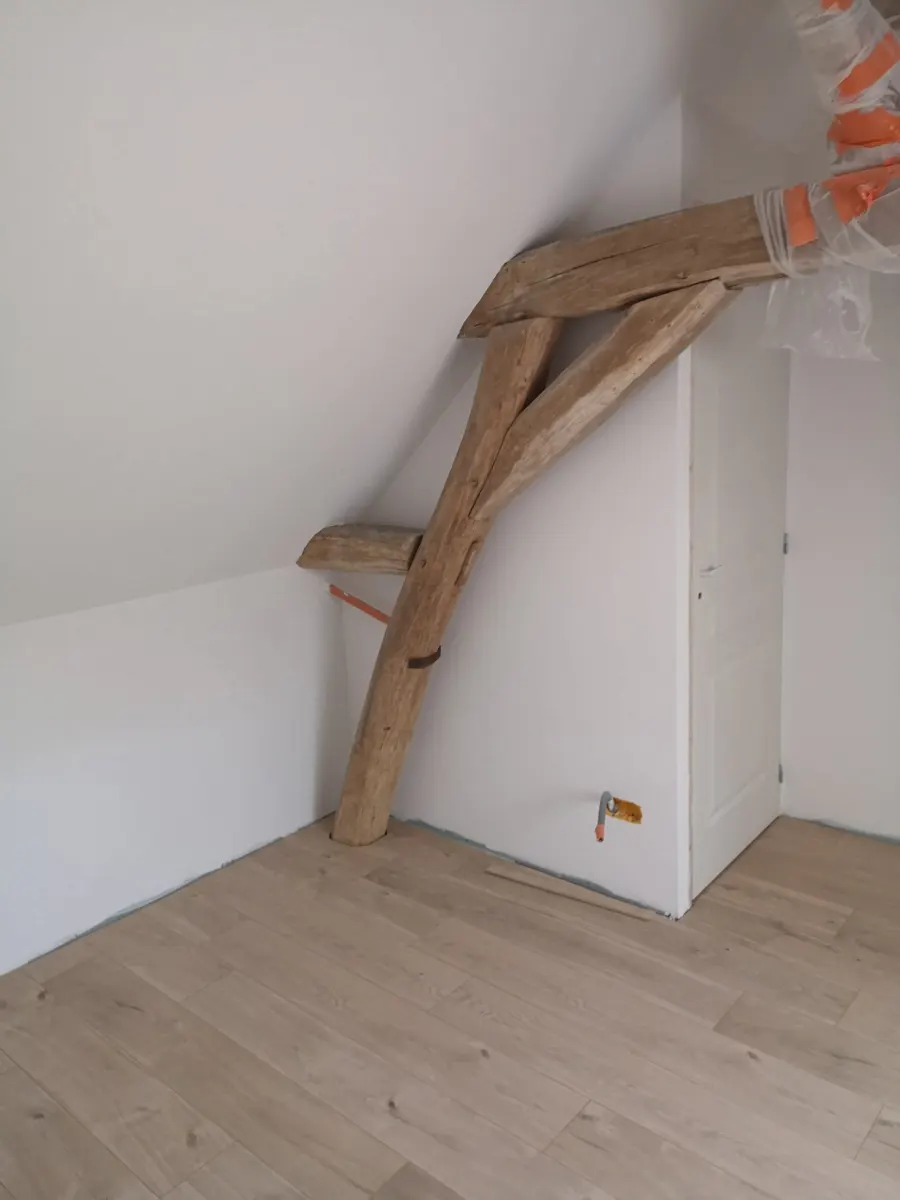 Rampant et mur blancs raccordés autour d’une poutre en bois apparente